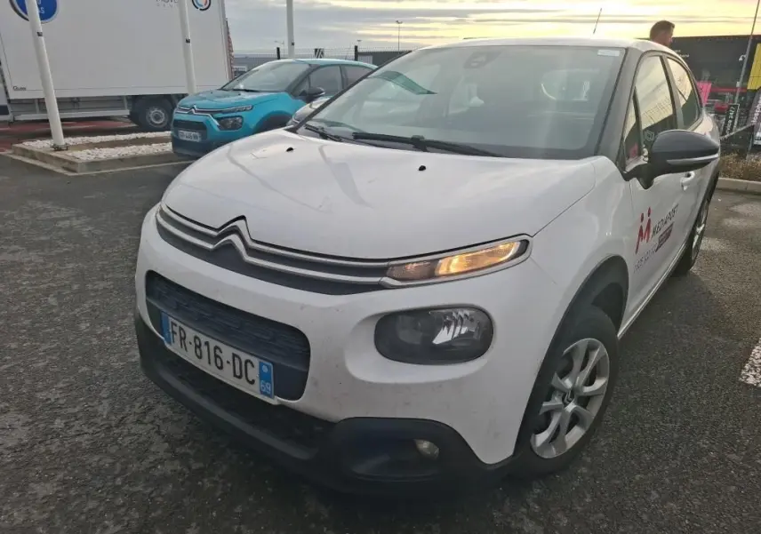 Vue 3/4 avant droit d'une Citroën C3 Société blanche de 2020 avec clignotant avant droit allumé et logo sur porte.