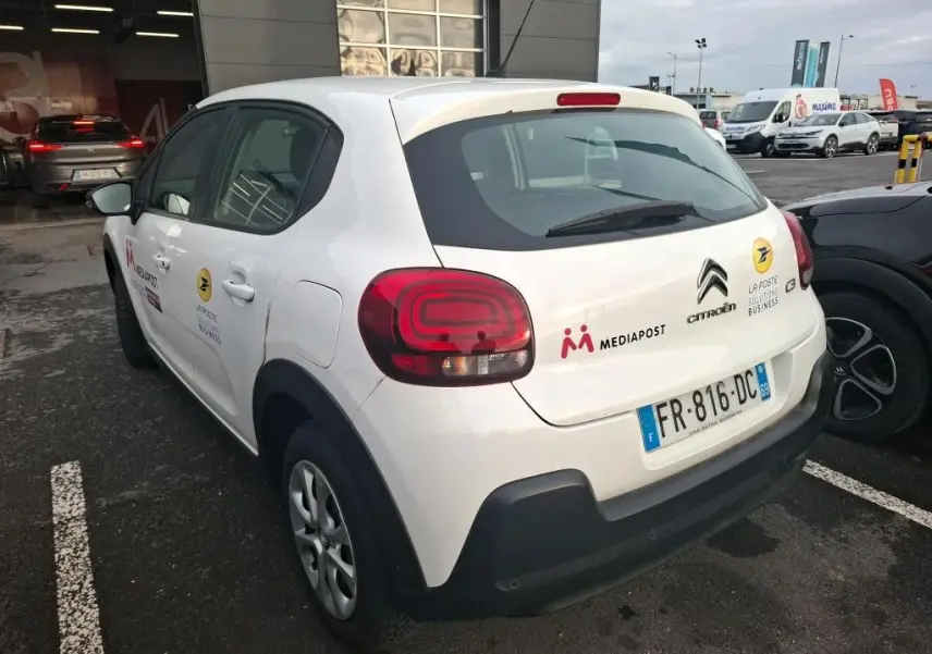 Vue 3/4 arrière droite d'une Citroën C3 Société blanche de 2020 avec logos Mediapost et La Poste sur le hayon.