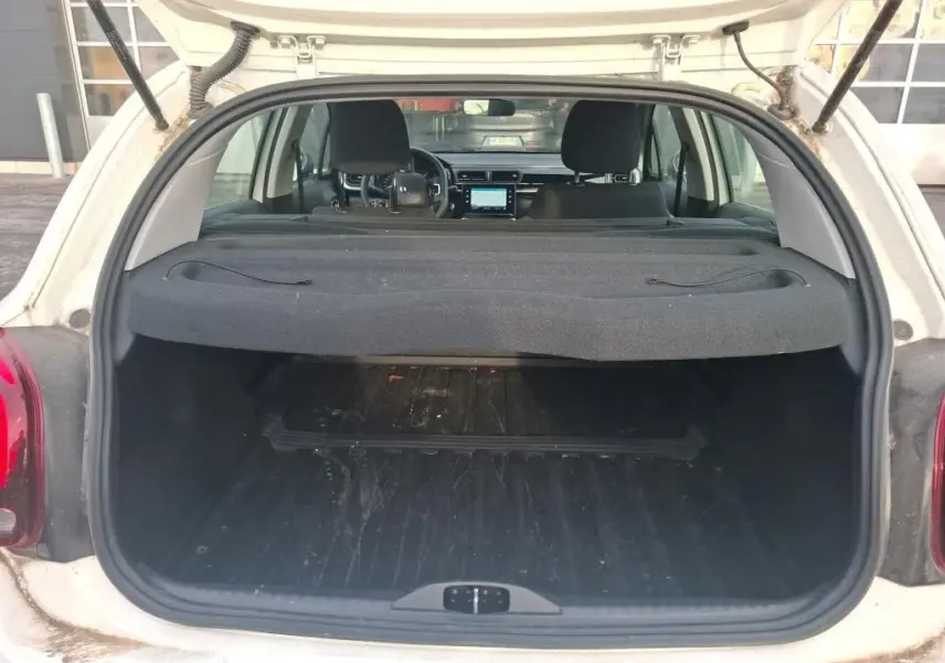 Vue arrière du coffre ouvert d'une Citroën C3 Société blanche, montrant l'intérieur spacieux et la tablette cache-bagages.