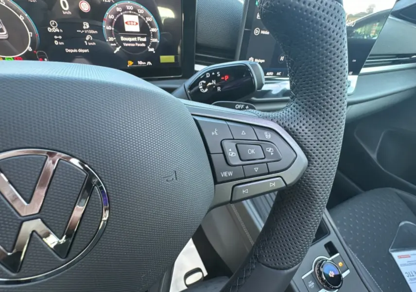 Gros plan sur le volant cuir perforé et les commandes multifonctions du tableau de bord du Volkswagen T-Roc noir.
