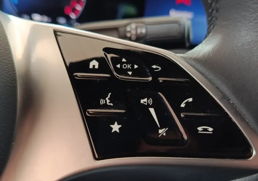 Gros plan sur les commandes tactiles noires du volant cuir du Mercedes GLA 250 e Business Line 2023.