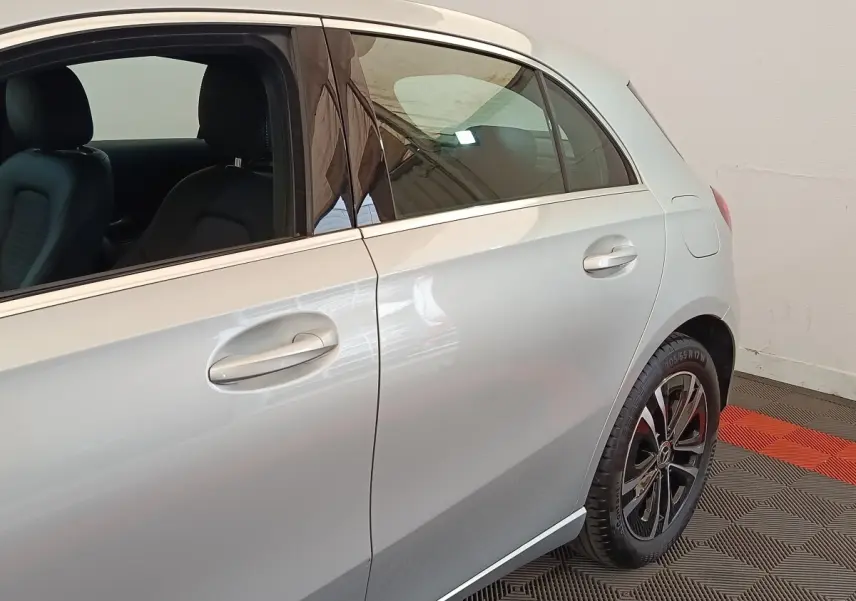 Vue latérale droite sur la porte arrière et jante noire d’un Mercedes GLA 250 e Business Line gris foncé.