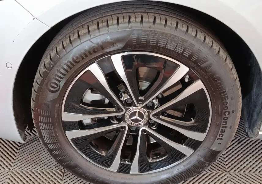 Gros plan sur la roue avant gauche d’une Mercedes GLA 250 e Business Line gris foncé avec jante alliage noir et argent.