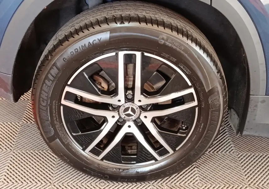 Gros plan sur la roue avant droite gris foncé du Mercedes GLA 250 e Business Line avec jante alliage noire et argentée.