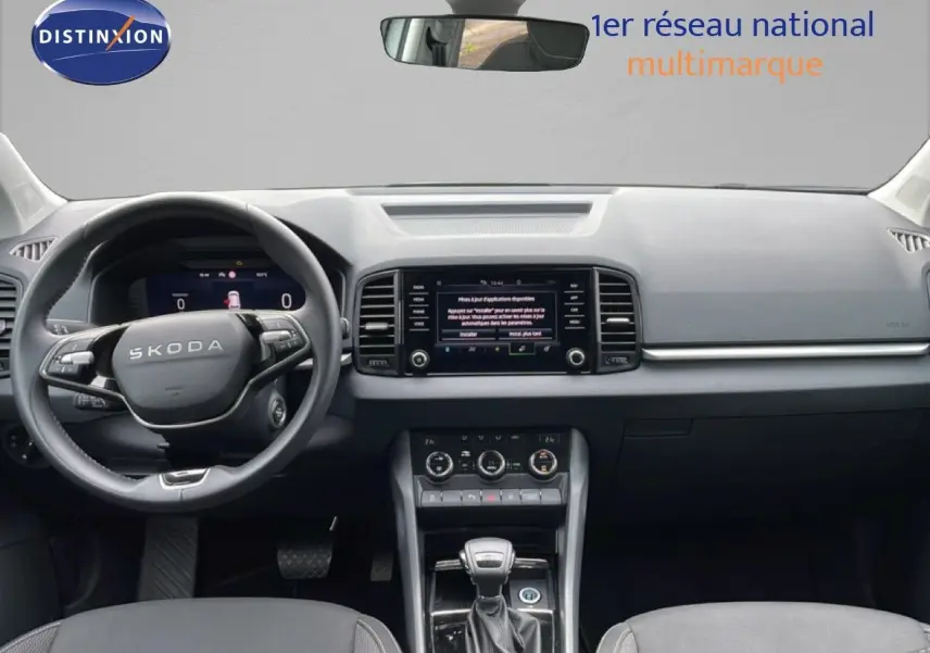 Vue frontale de l’habitacle noir du Skoda Karoq 2025 avec tableau de bord moderne et écran tactile central.