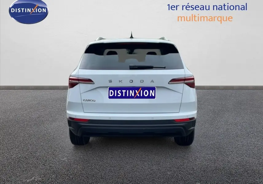 Vue arrière d'un Skoda Karoq blanc glacier 2025, avec feux arrière LED et logo SKODA bien visible.