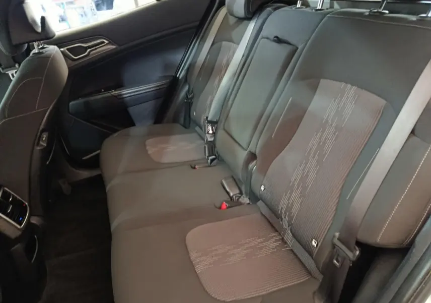 Vue intérieure côté gauche montrant la banquette arrière noire du Kia Sportage 2022 hybride rechargeable.