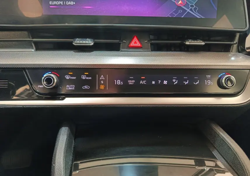 Gros plan sur la console centrale du Kia Sportage blanc 2022, affichage digital de la climatisation et commandes tactiles.