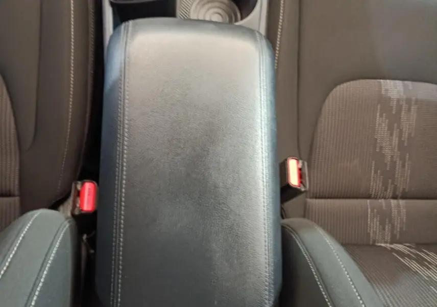 Vue plongeante sur l'accoudoir central noir et les sièges avant gris du Kia Sportage hybride rechargeable 2022.