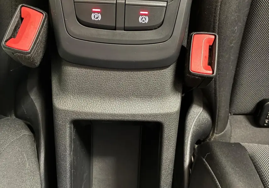 Vue rapprochée de la console centrale noire de l'Audi Q2 2020, avec boutons de frein à main et arrêt automatique éclairés.
