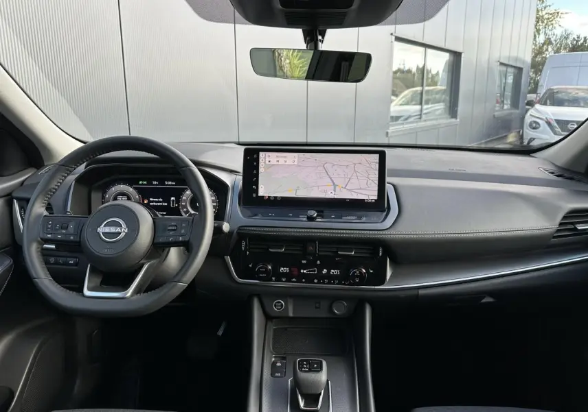 Vue intérieure avant du Nissan Qashqai 2025 noir nacré, tableau de bord moderne avec écran tactile et volant cuir.