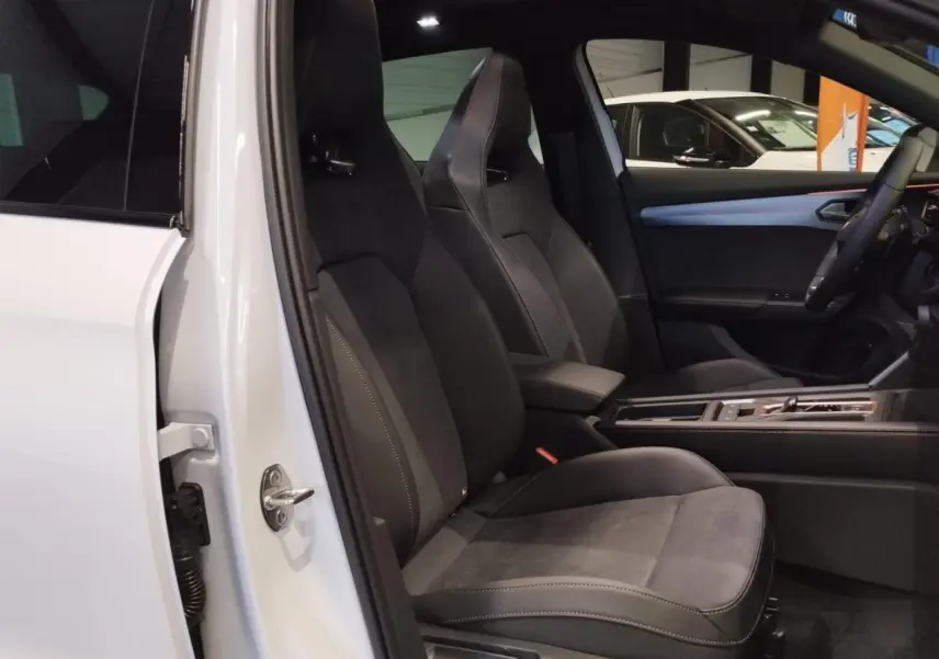 Vue intérieure côté conducteur du CUPRA Formentor blanc Nevada, sièges baquets suédine noir avec surpiqûres cuivrées.