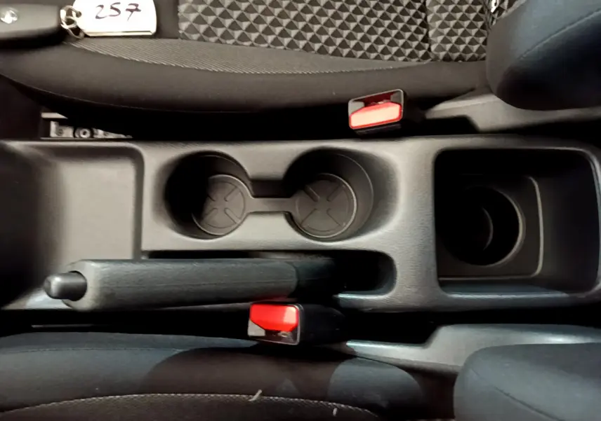 Vue plongeante sur la console centrale noire de la Nissan Micra Acenta 2022, montrant frein à main et porte-gobelets.