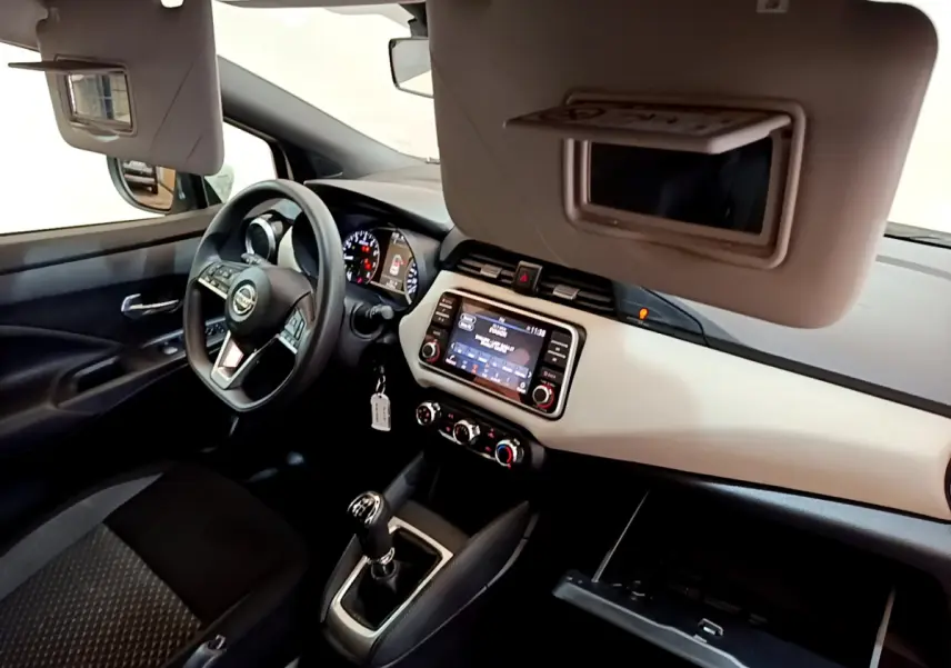 Intérieur avant droit de la Nissan Micra IG-T 92 Acenta 2022 blanche, tableau de bord clair et volant multifonctions.