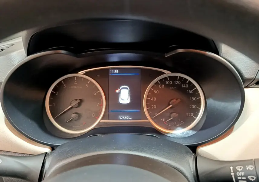 Vue rapprochée du tableau de bord de la Nissan Micra blanche 2022, affichant compte-tours, vitesse et écran central.