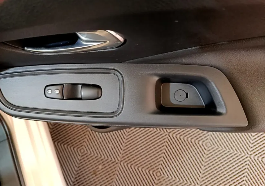 Gros plan sur la commande de verrouillage des portes côté conducteur d'une Nissan Micra blanche 2022.