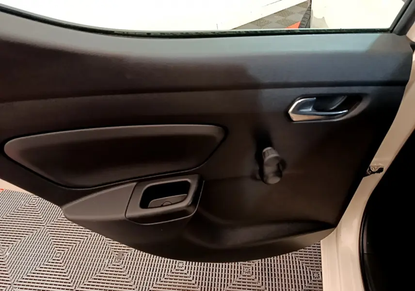 Vue intérieure sur la porte côté droit noire d'une Nissan Micra blanche 2022 avec poignée et manivelle de vitre.