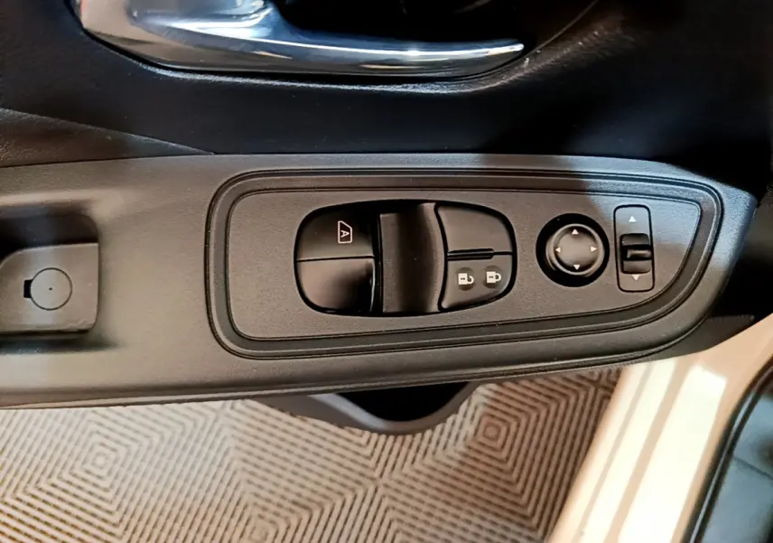 Gros plan sur les commandes de lève-vitres et rétroviseurs côté conducteur d'une Nissan Micra blanche 2022.