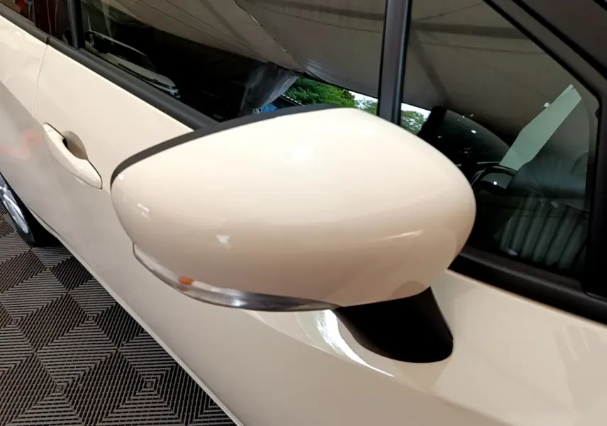 Gros plan sur le rétroviseur côté gauche blanc de la Nissan Micra IG-T 92 Acenta 2022 avec poignée de porte assortie.