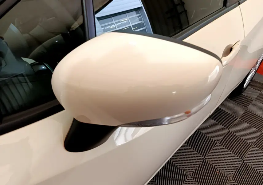 Gros plan sur le rétroviseur côté gauche blanc de la Nissan Micra IG-T 92 Acenta 2022, avec clignotant intégré.