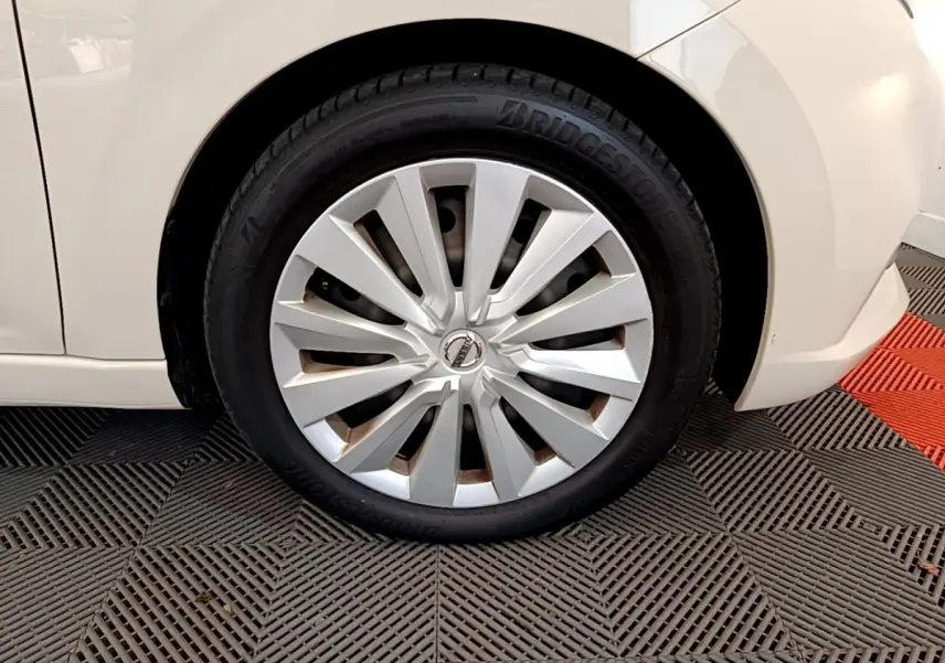 Gros plan sur la roue avant gauche blanche d'une Nissan Micra IG-T 92 Acenta 2022 avec jante en alliage argenté.