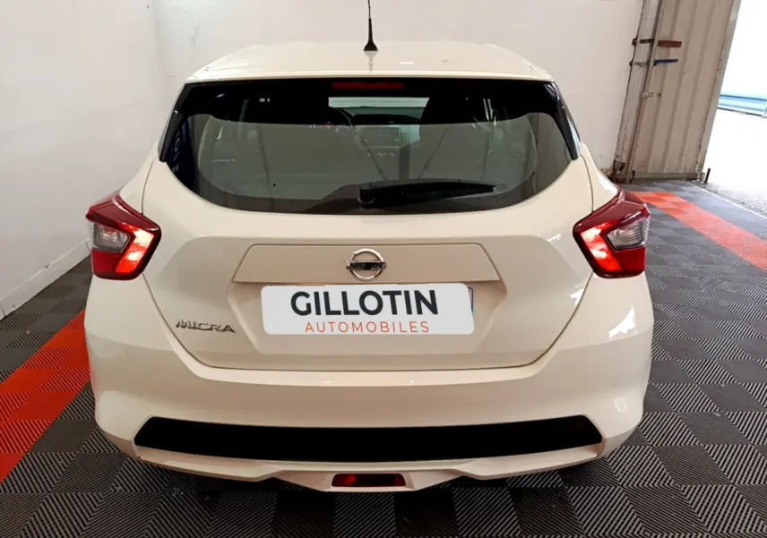 Vue arrière d'une Nissan Micra blanche 2022 garée en intérieur avec feux arrière LED allumés.