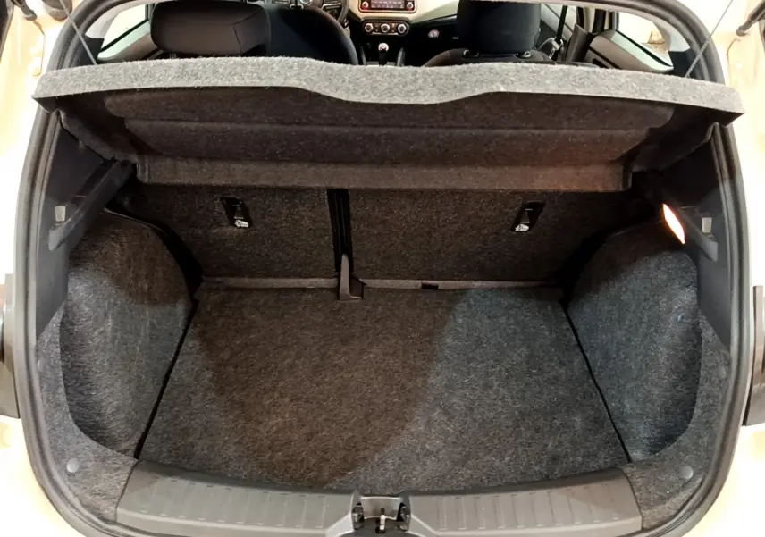 Coffre ouvert d'une Nissan Micra blanche 2022, vue de l'arrière montrant l'espace de chargement et l'intérieur partiel.