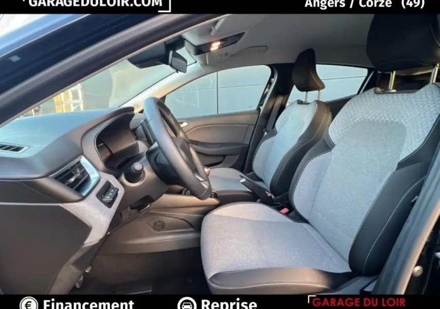 Vue intérieure côté conducteur de la Renault Clio noire 2025 avec sièges tissu clair et volant multifonctions cuir synthétique.