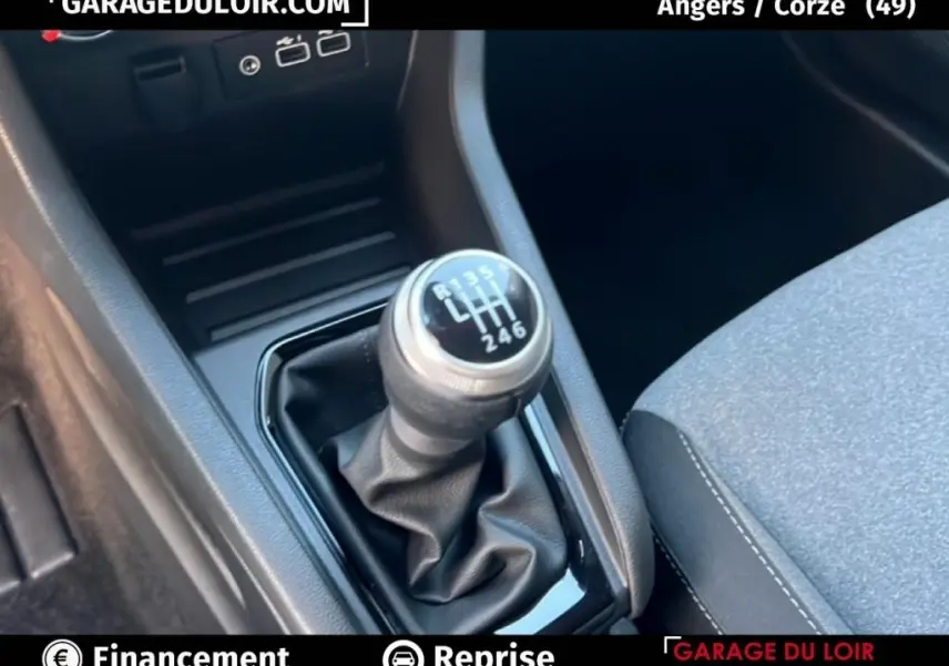 Gros plan sur le levier de vitesse manuel noir et argenté de la Renault Clio Evolution TCe 90, intérieur gris et noir.