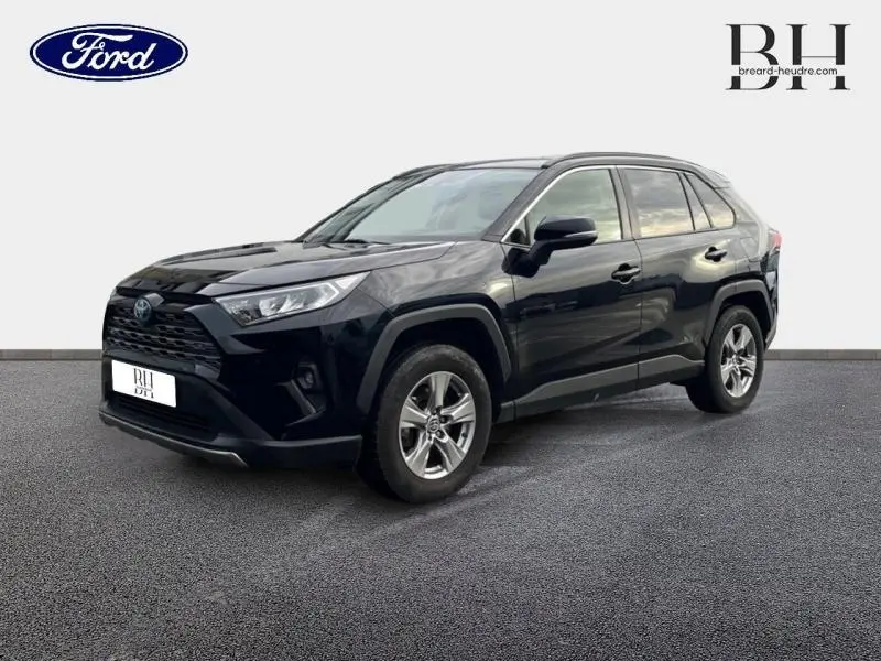 Toyota RAV4 noir métallisé vu en 3/4 avant droit avec jantes alu et calandre noire distinctive.