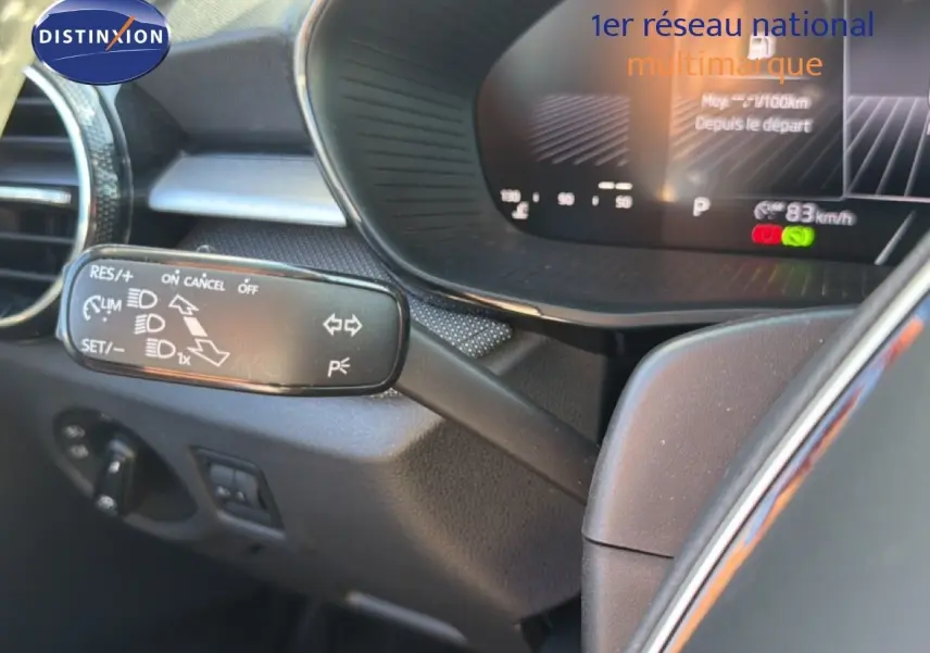 Gros plan sur la commande de régulateur de vitesse à gauche du volant dans l’habitacle d’une Skoda Fabia gris graphite.