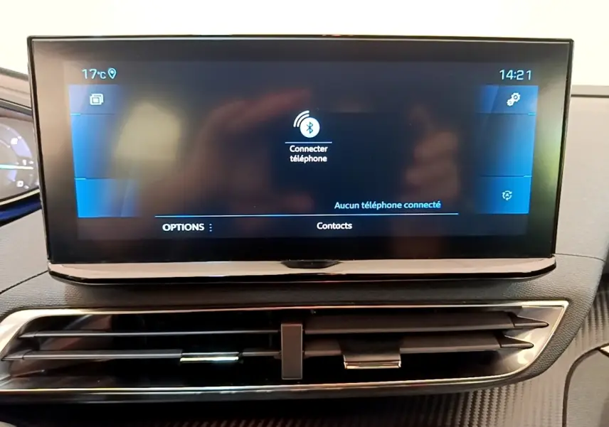 Écran tactile central allumé dans l’habitacle du Peugeot 3008 bleu, affichant la connexion Bluetooth téléphone.