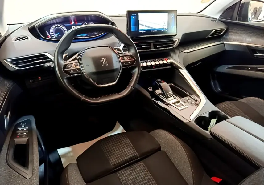 Vue intérieure avant du Peugeot 3008 2022 montrant le volant cuir, l’écran tactile central et la console avec boîte automatique.