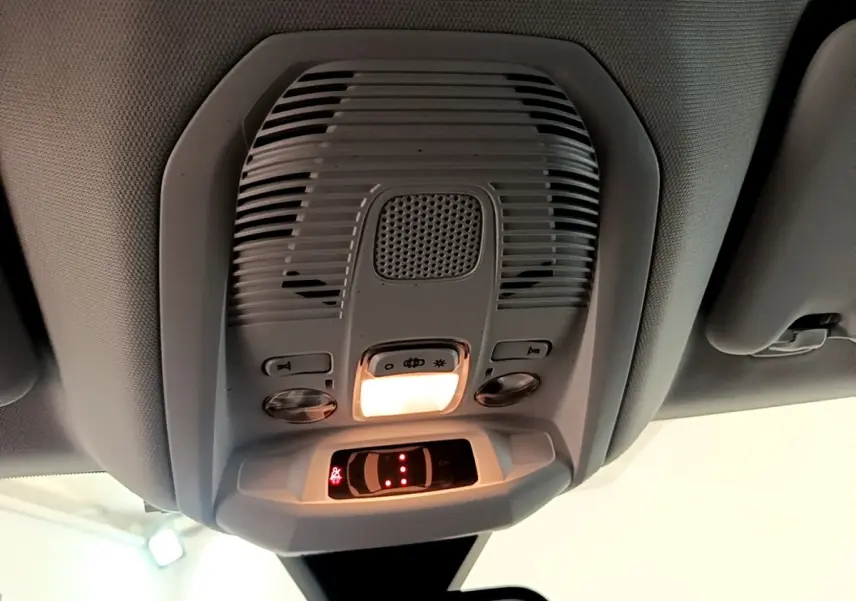Vue en contre-plongée du plafonnier gris avec éclairage intérieur allumé du Peugeot 3008 bleu 2022.