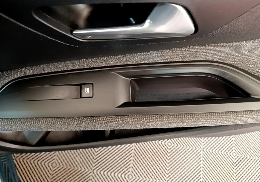 Gros plan sur la poignée intérieure et commande de lève-vitre côté gauche du PEUGEOT 3008 bleu, finition Active Pack 2022.