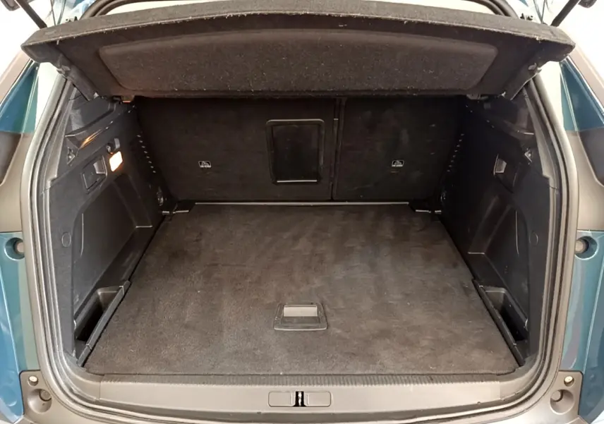 Coffre ouvert vu de l'arrière d'un Peugeot 3008 bleu 2022, montrant un espace de chargement propre et spacieux.