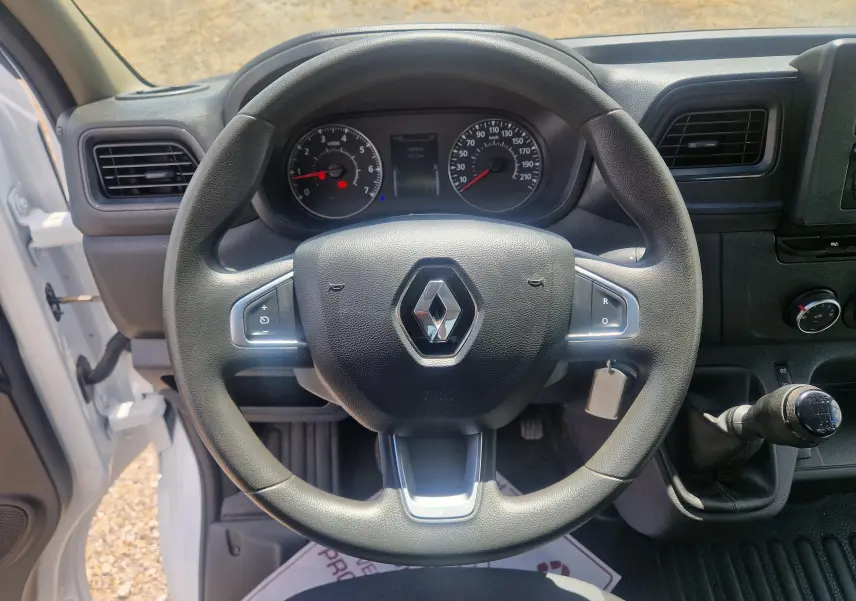 Vue intérieure centrée sur le volant noir du Renault Master Châssis Cabine blanc avec levier de vitesse manuel visible à droite.