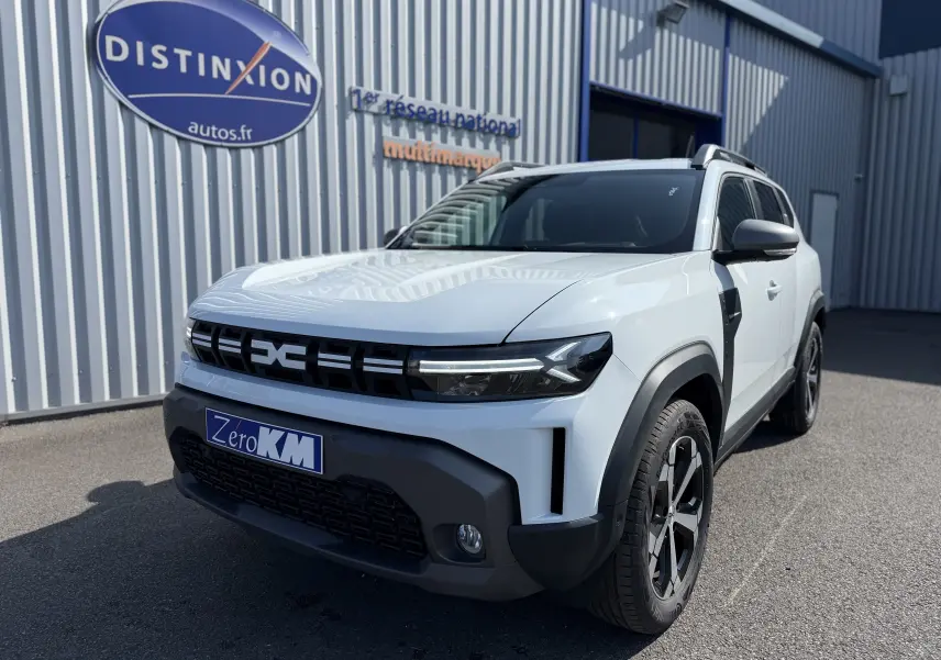 Vue 3/4 avant droit du Dacia Duster Hybrid 155 Journey blanc glacier avec calandre noire et jantes noires.