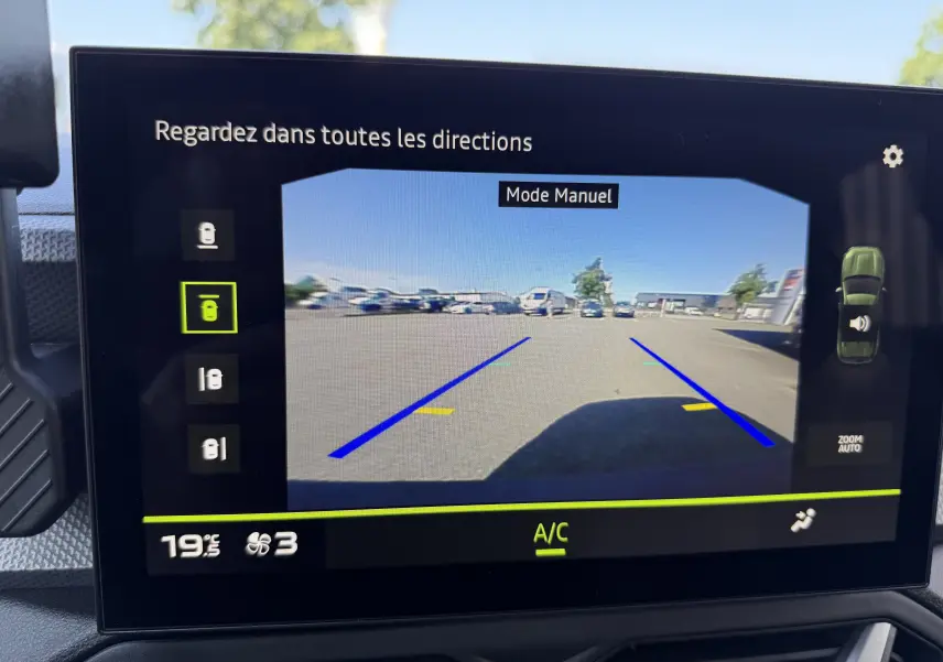 Écran de caméra de recul du Dacia Duster Hybrid 155 Journey 2026 montrant une vue arrière avec lignes de guidage bleues.