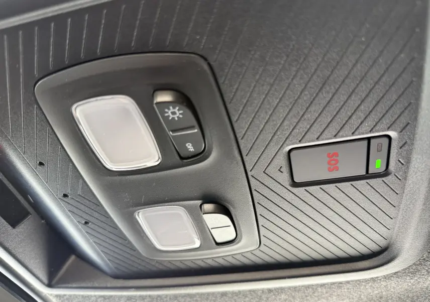 Vue en gros plan du plafonnier noir avec commandes d’éclairage et bouton SOS du Dacia Duster blanc Glacier 2026.