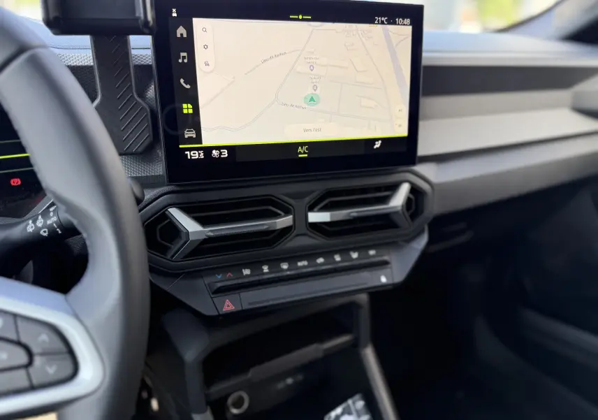 Vue intérieure du tableau de bord du Dacia Duster Hybrid 155 Journey 2026, écran tactile avec navigation et aérateurs hexagonaux.