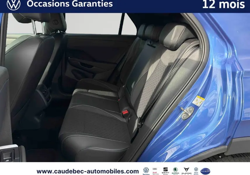 Vue intérieure arrière côté droit du Volkswagen T-Roc bleu, montrant les sièges arrière en cuir noir avec inserts tissu.