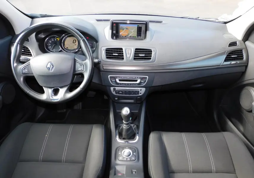 Vue intérieure avant de la Renault Mégane noire de 2015, avec tableau de bord et écran GPS central visible.