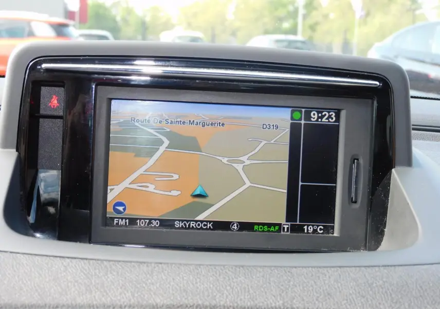 Écran GPS Carminat TomTom affichant une carte routière dans l'habitacle de la Renault Mégane noire de 2015.