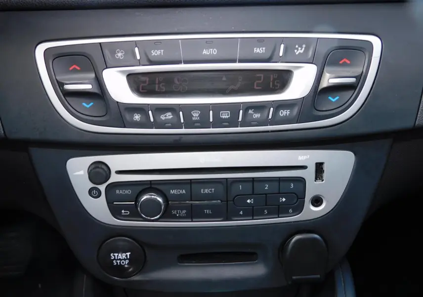 Vue rapprochée de la console centrale noire de la Renault Mégane 2015 avec commandes climatisation et bouton start/stop.