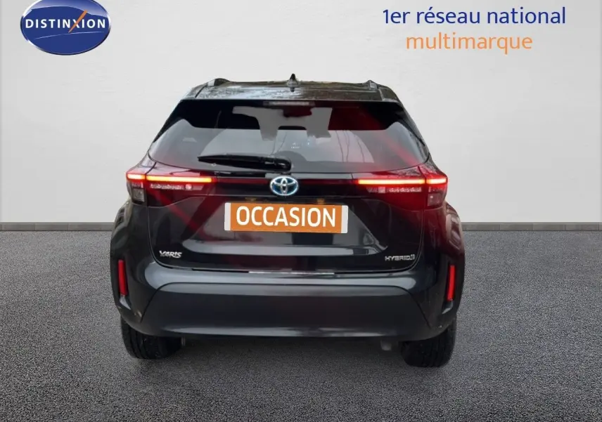 Vue arrière d'une Toyota Yaris Cross 116h Design noire de 2023 avec feux allumés et plaque occasion.