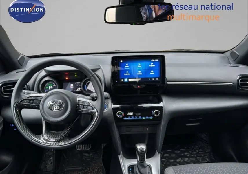Vue intérieure avant du Toyota Yaris Cross noir 2023, tableau de bord moderne avec écran tactile central et volant multifonction.