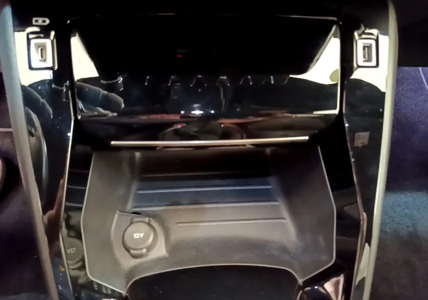 Gros plan sur la console centrale noire de la Peugeot 208 GT Line 2020 avec prise 12V visible.