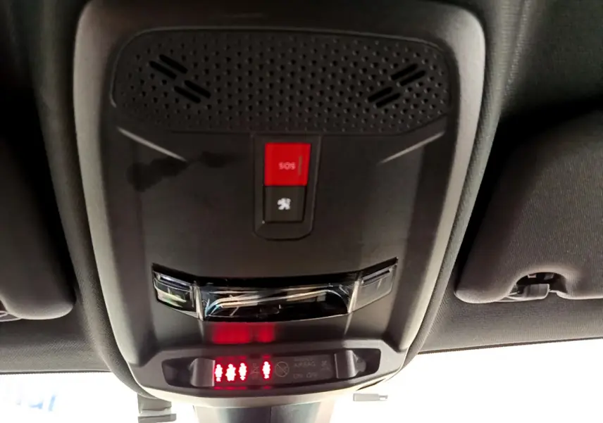 Vue en gros plan du plafonnier intérieur avec bouton SOS rouge et indicateurs de ceinture du Peugeot 208 rouge GT Line 2020