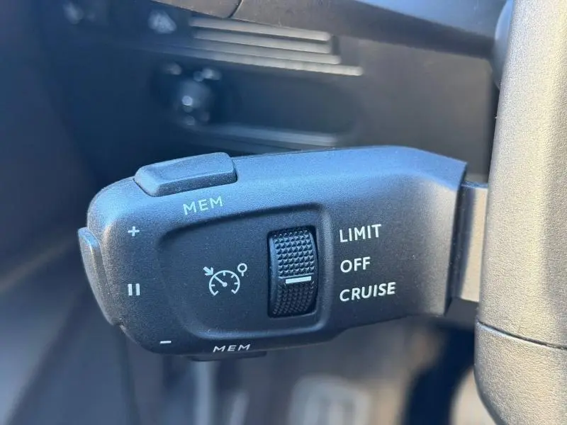 Gros plan sur la commande de régulateur de vitesse noire à gauche du volant dans un DS3 Crossback 2020.